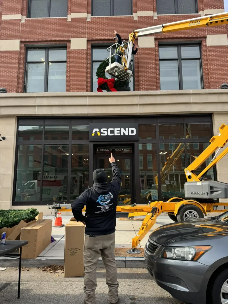 A GrimeBusters Soft Wash and Holiday Lighting Team Member Installs Commercial Christmas Lights.