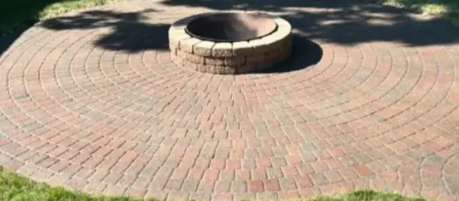 A Clean Section of Pressure Washed and Resealed Patio Pavers Lay Around a Fireplace of a Pittsburgh Home.